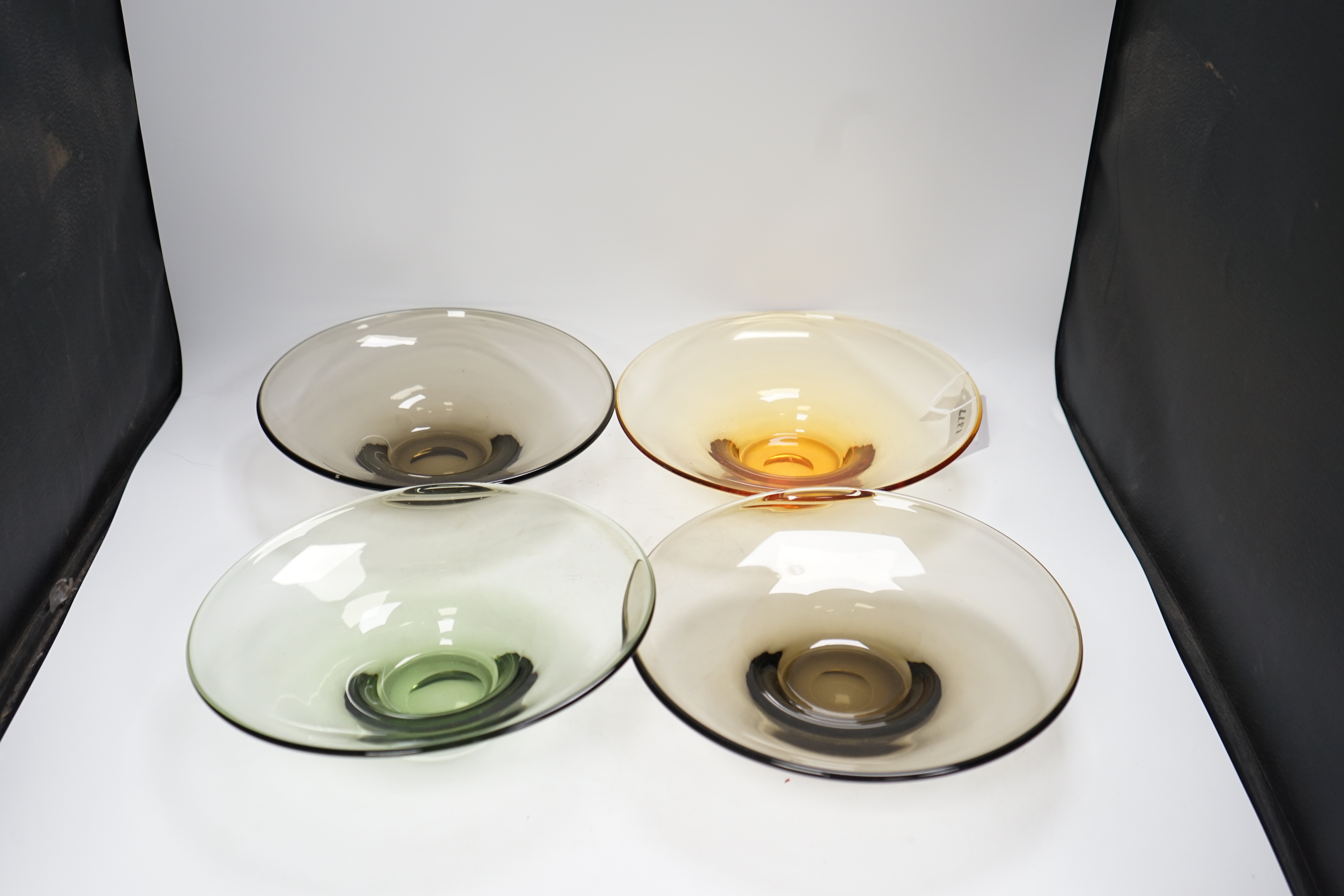 Four colour tinted glass dishes, largest 28cm diameter